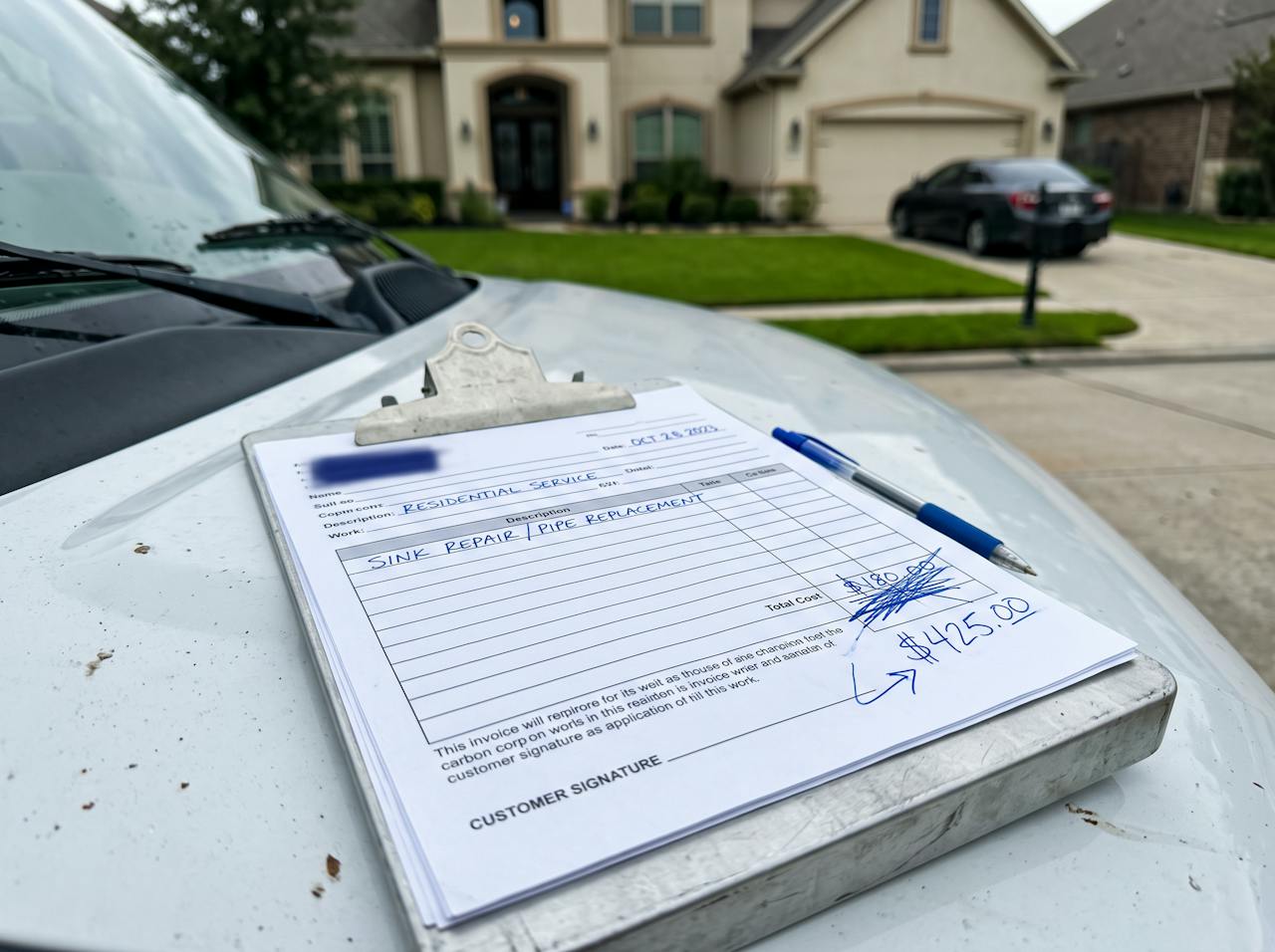Plumber invoice with the price crossed out and raised, large suburban house in the background